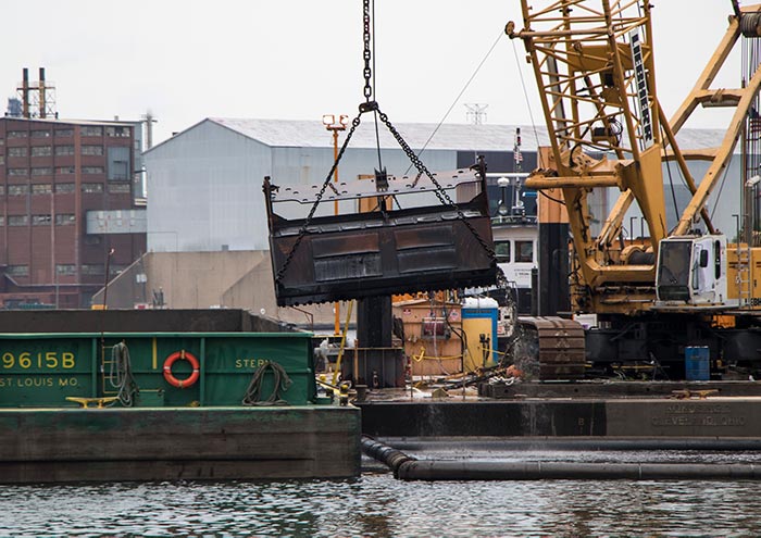 photo of crane, bucket, and barge